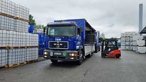 ein Gabelstapler belädt den blauen LKW vom THW mit IBC auf dem Firmengelände von Bayern-Fass in Mainburg